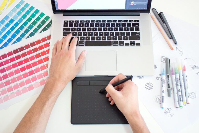 An illustrator uses a computer and drawing tablet